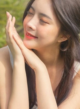 눈을 감고 두 손을 턱 아래 모은 긴 머리 여성 모델
